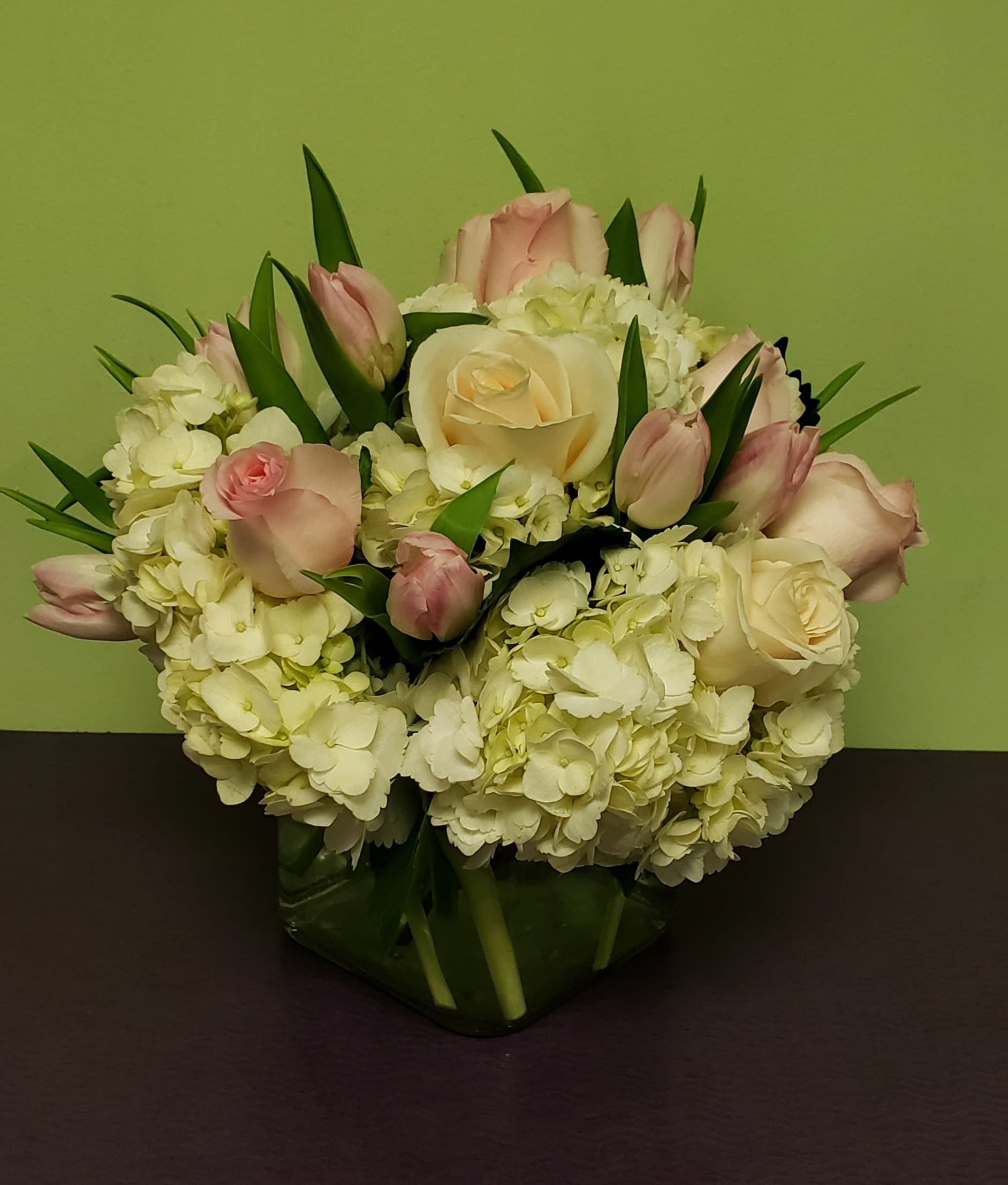Pink and white roses with hydrangeas in a glass vase