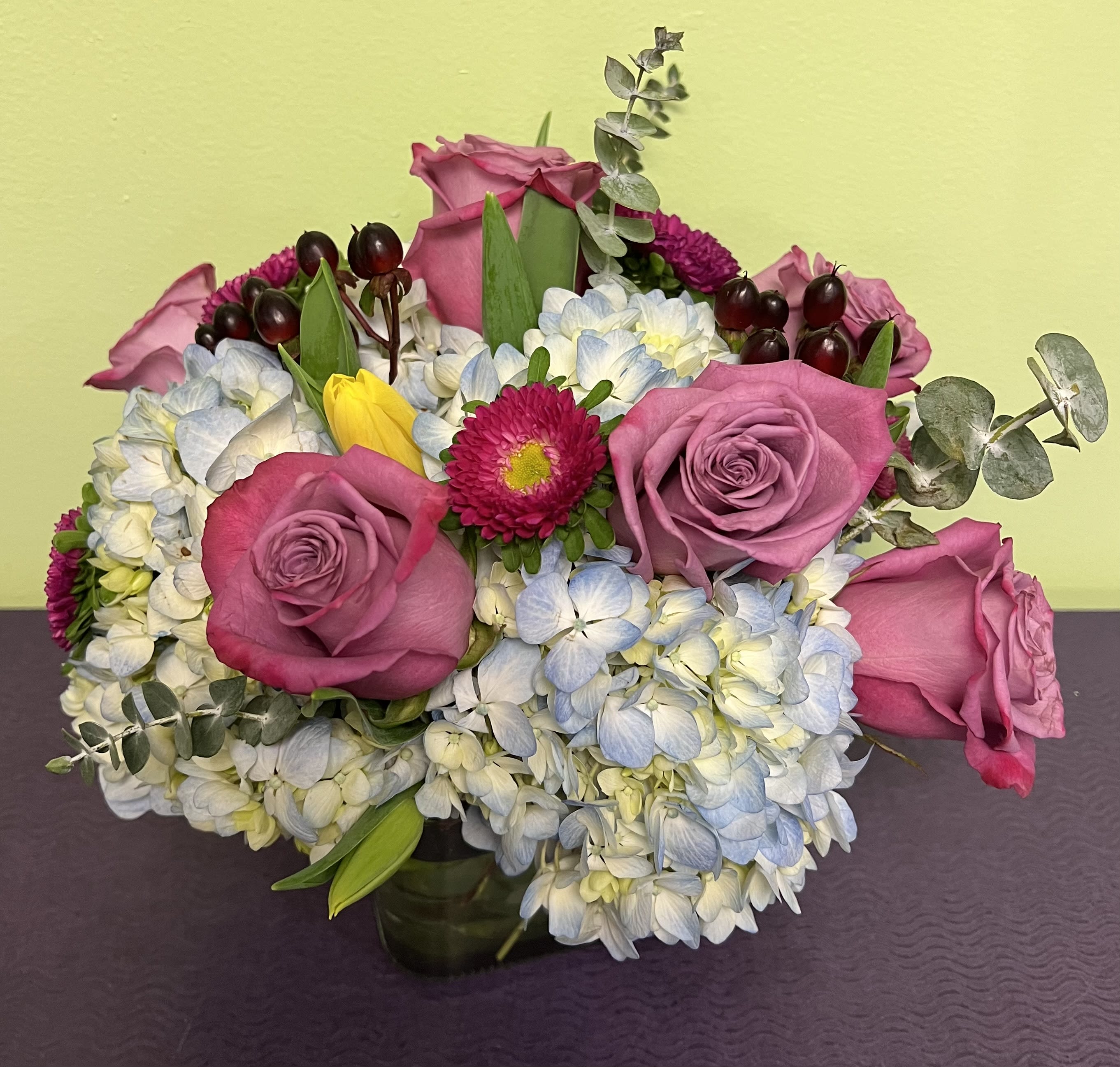 Pink roses and blue-white hydrangeas in a low vase arrangement