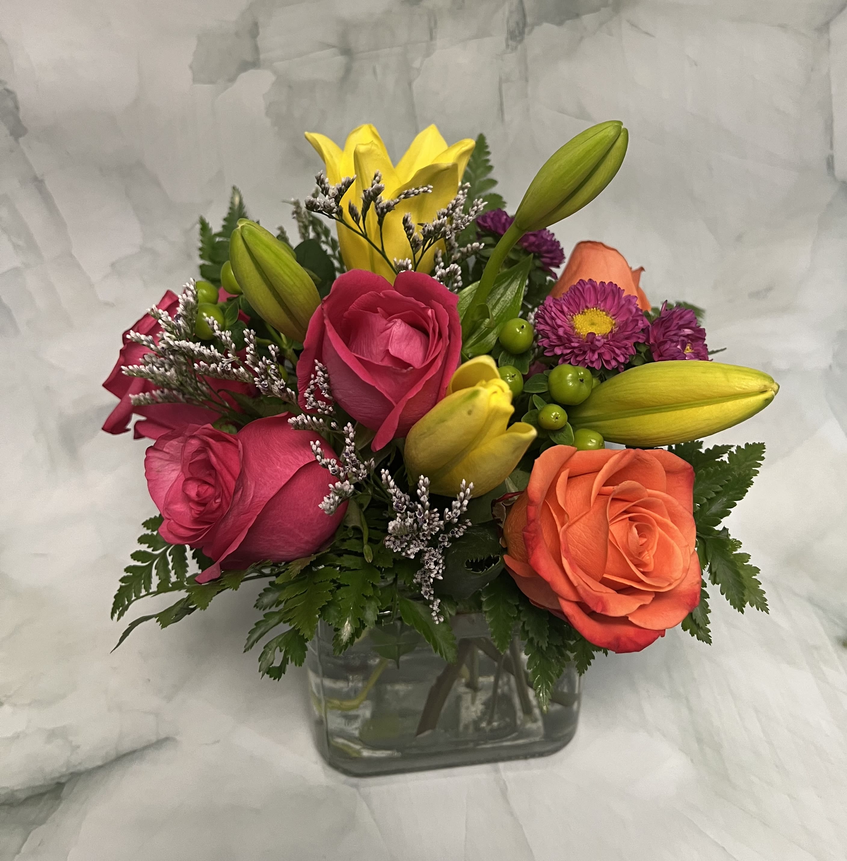 Mixed bouquet of roses and lilies in a glass vase