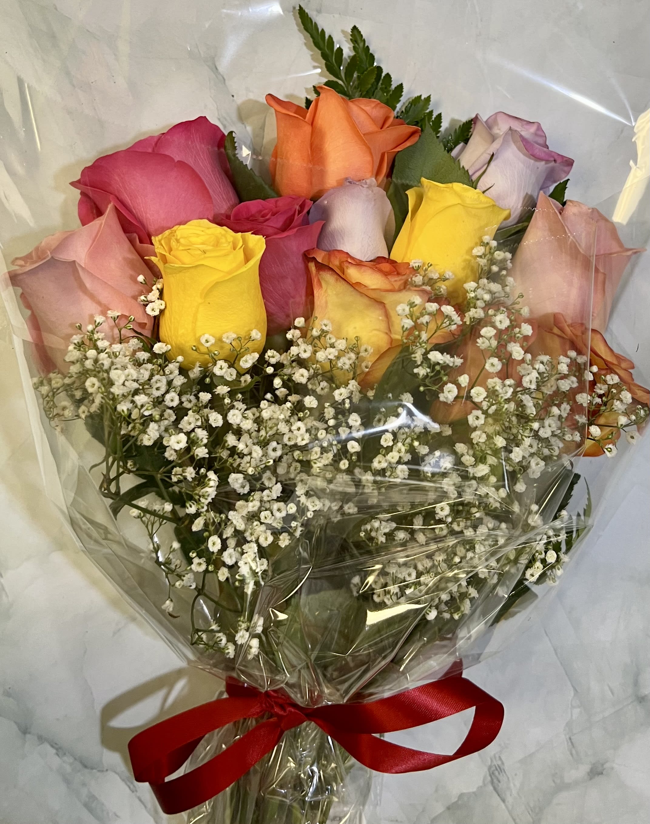 Bouquet of multicolored roses with baby's breath wrapped in clear plastic