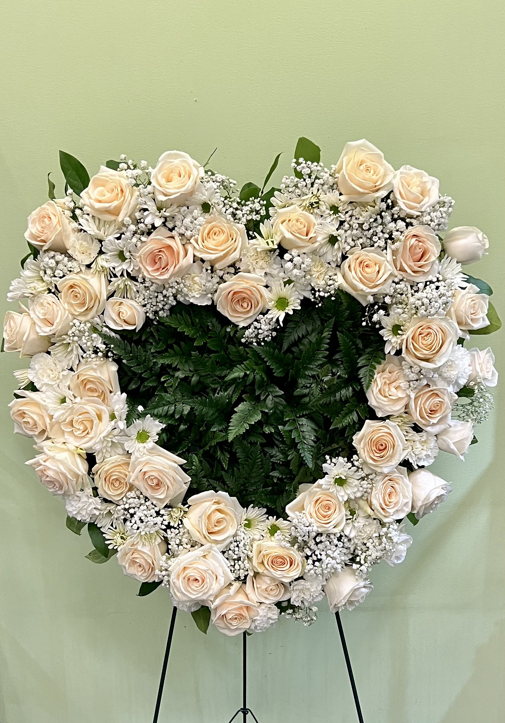 Heart-shaped floral wreath of cream roses and white filler flowers