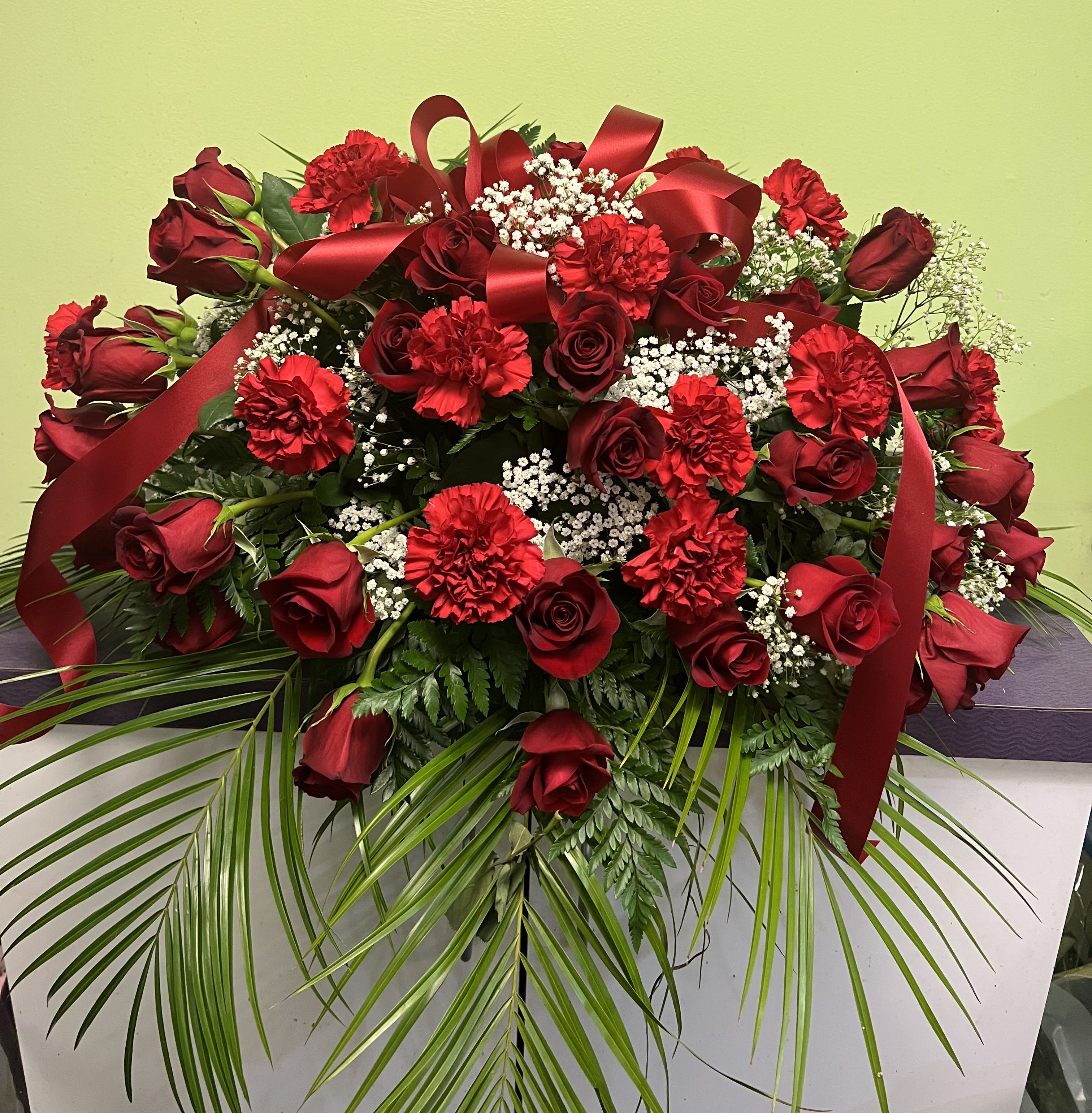 Large red rose and carnation arrangement with ribbon and baby's breath