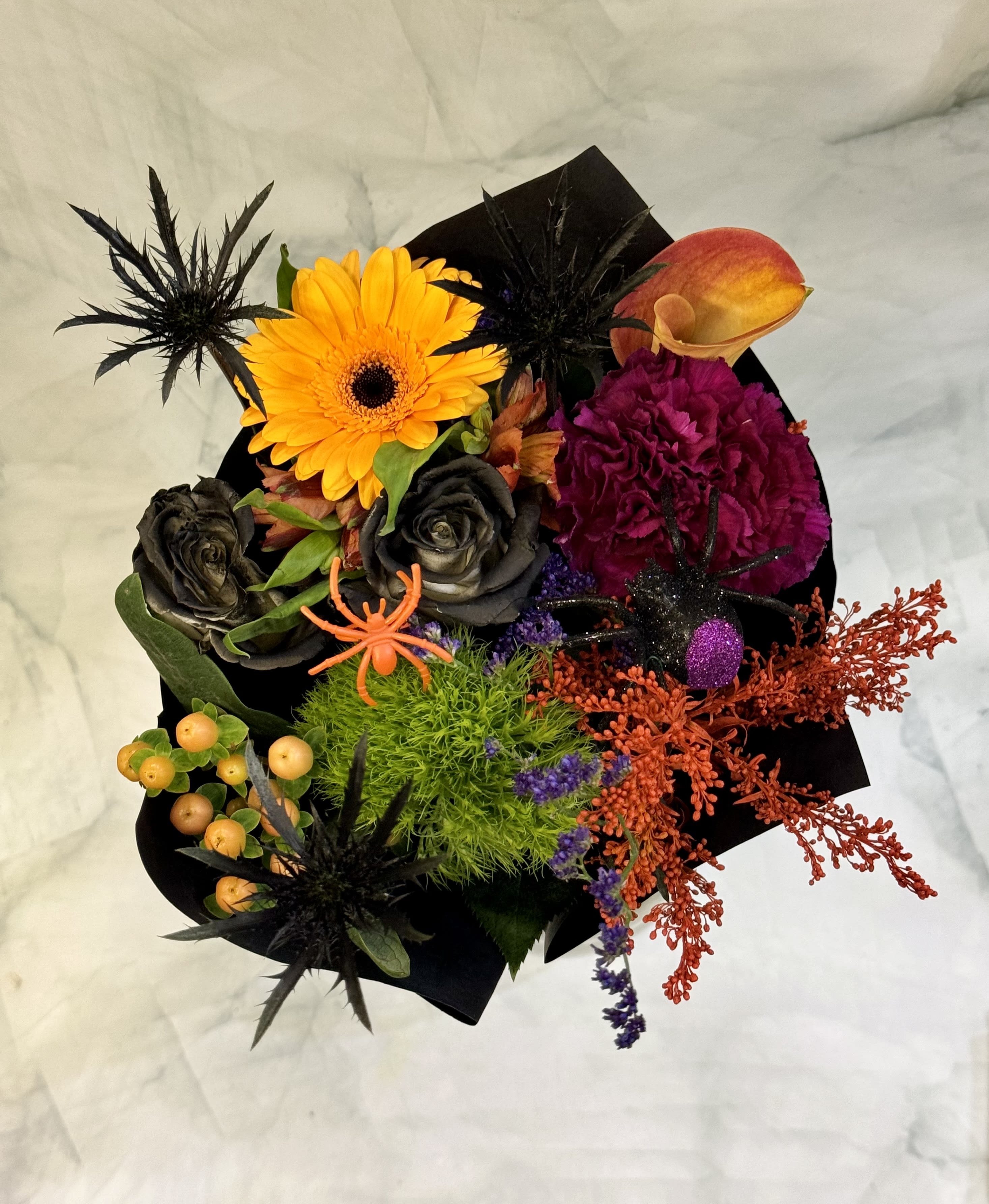 Halloween bouquet with orange gerbera, black roses, and a calla lily