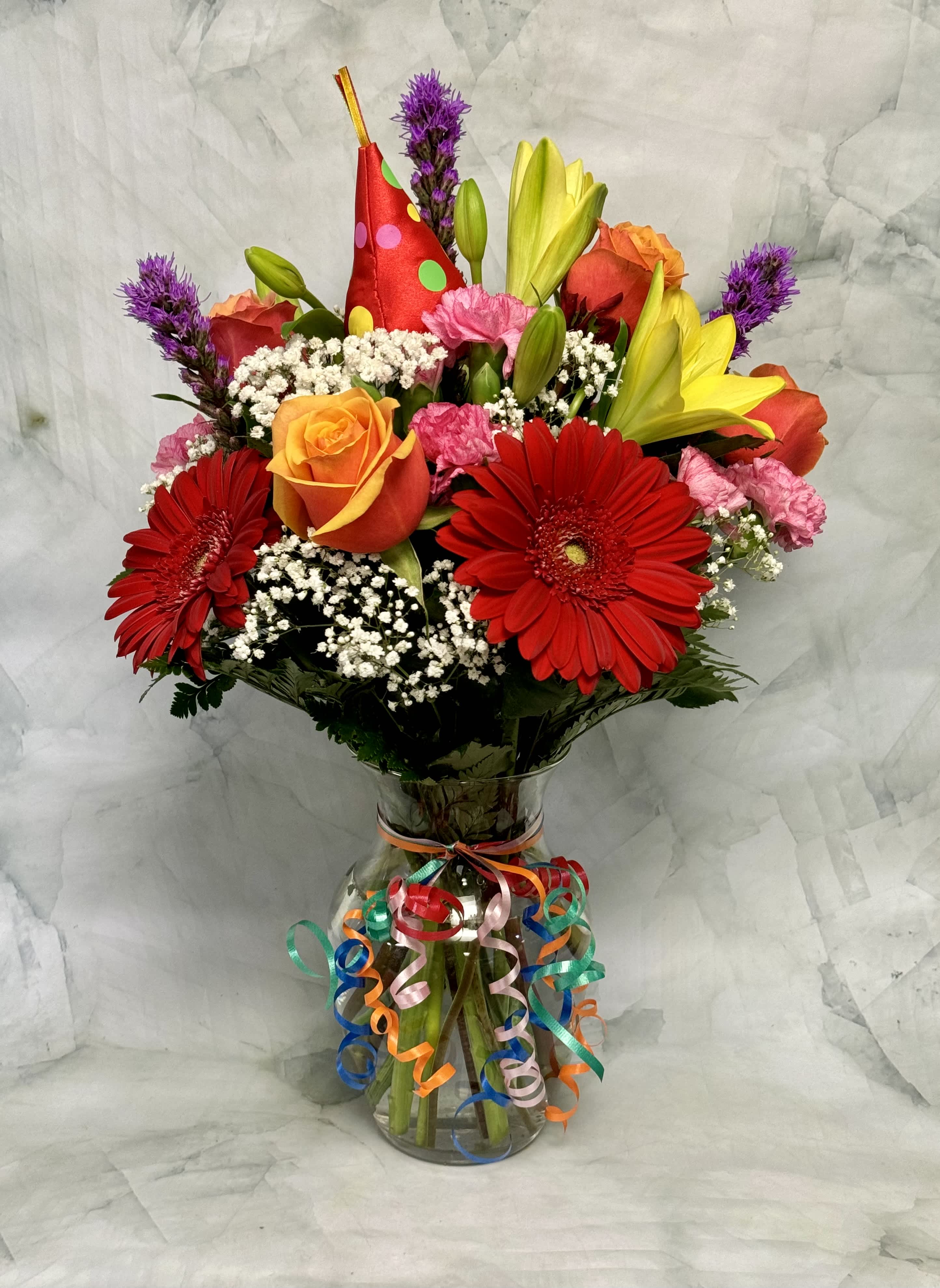 It's My Party! - Party on with this fun and vibrant arrangement. This arrangement is ready to party and even arrives wearing a party hat! Celebrate with gerbera daisies, roses, mini carnations, lilies, liatris and baby's breath. 