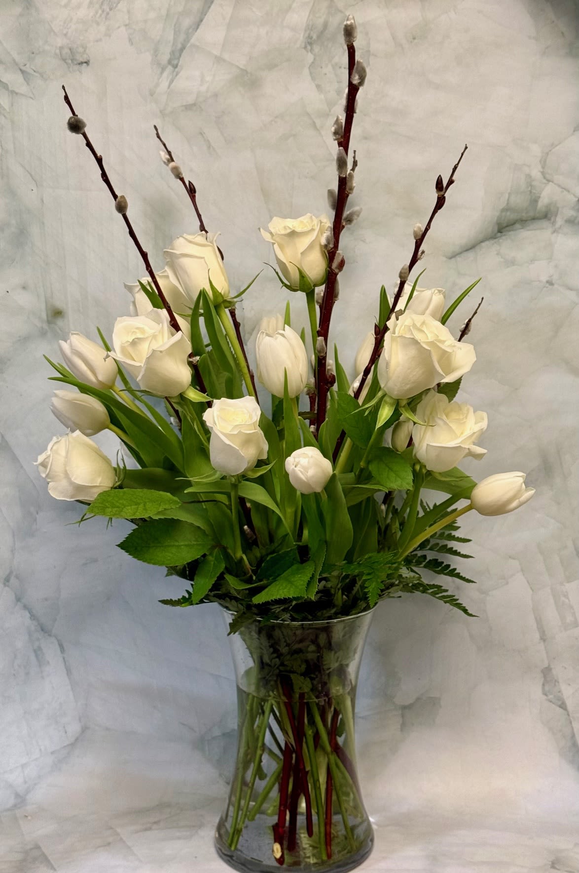 White tulips and roses in a clear glass vase