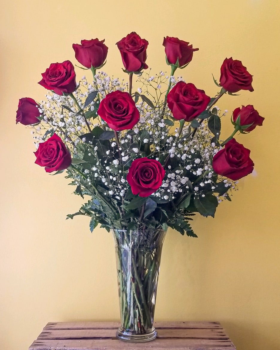 Tall vase arrangement of red roses with white baby's breath