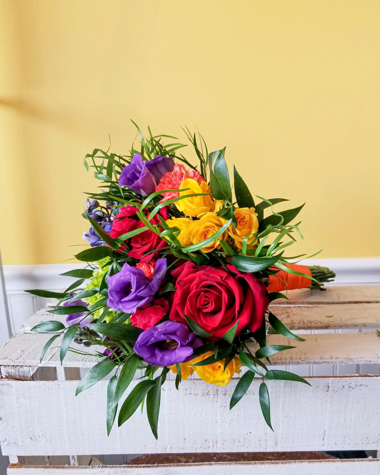 Bouquet of multicolored roses and purple lisianthus with greenery