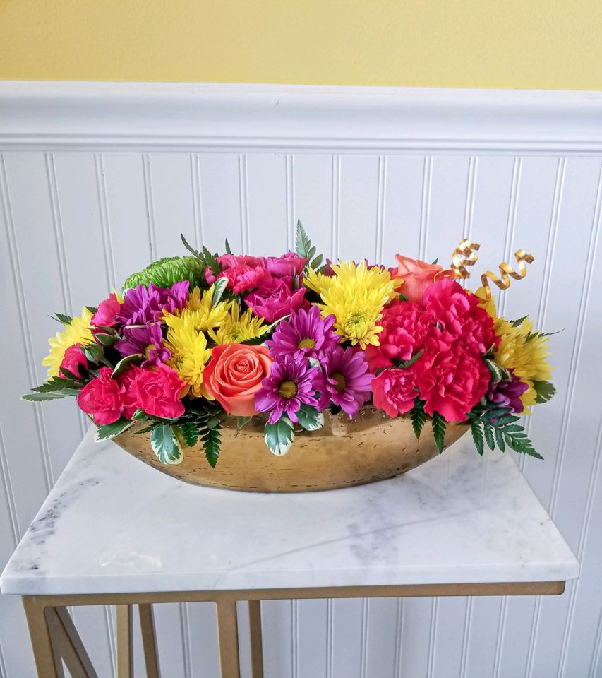 Bright mixed flower arrangement in a gold bowl