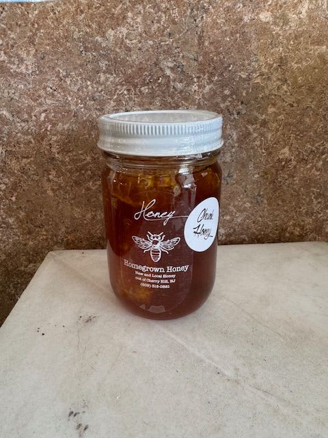 Jar of honey with a silver lid on a countertop