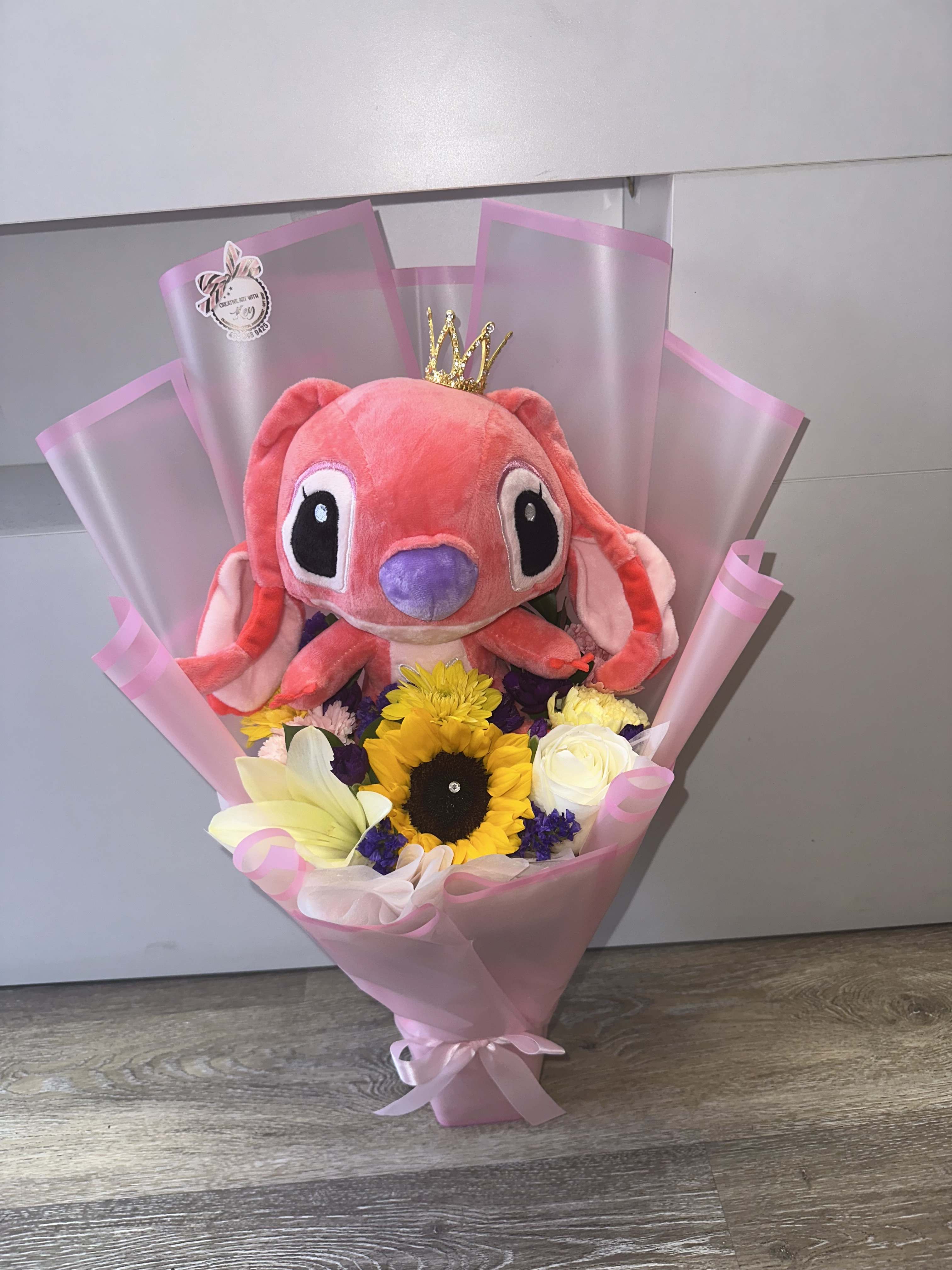 Pink plush toy bouquet with sunflowers and white roses in pink wrap