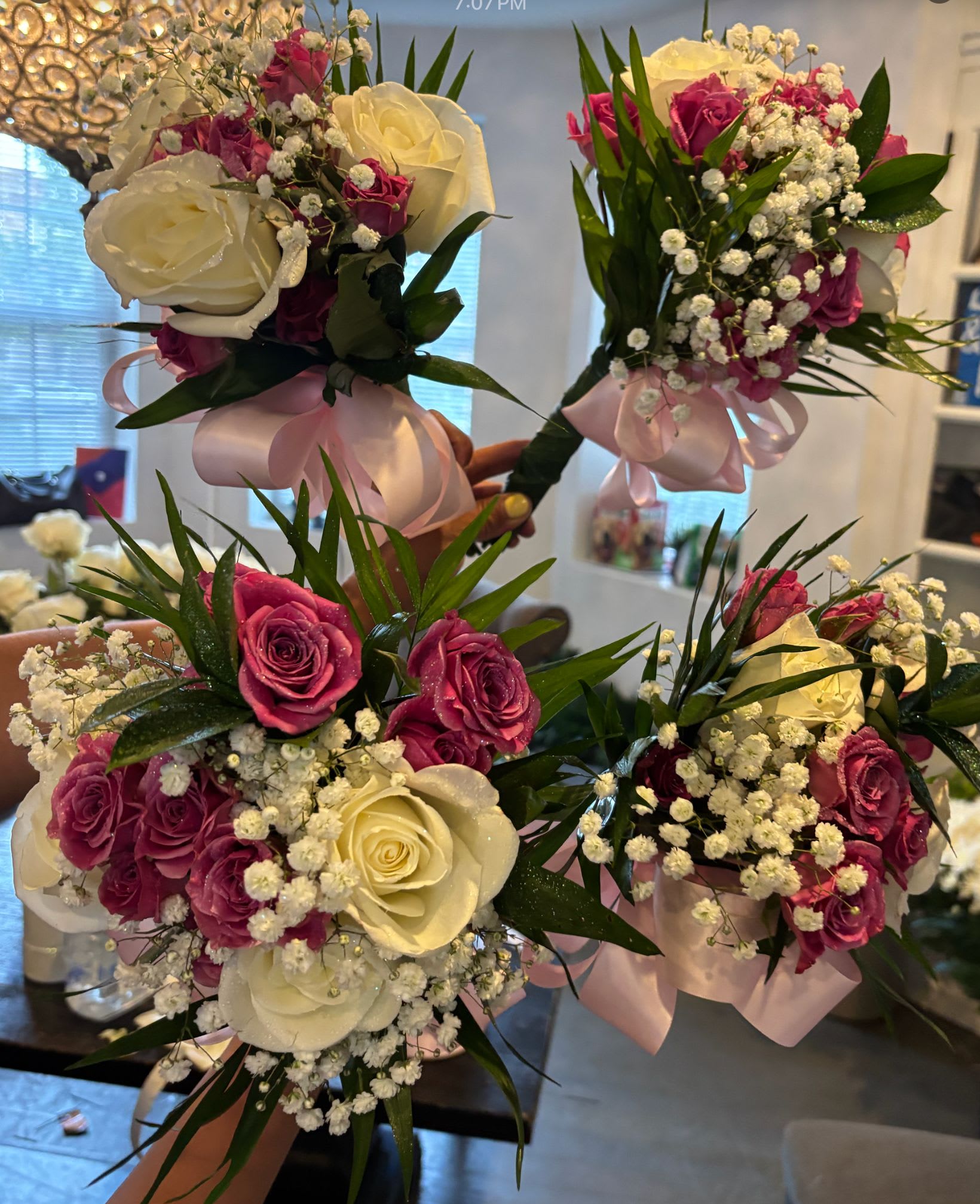 Handheld bouquets of white and pink roses with baby's breath and ribbon