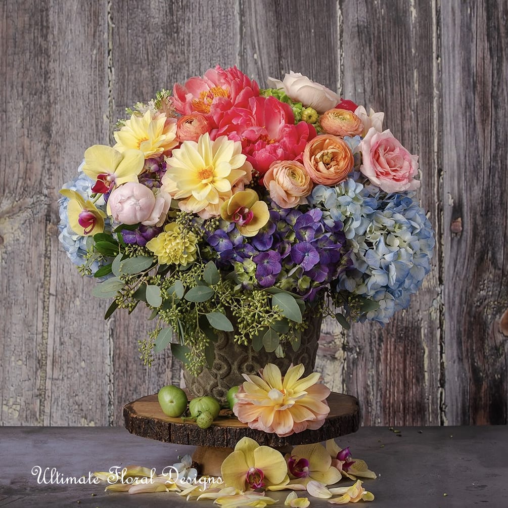 Colorful bouquet in a decorative vase with hydrangeas, roses, and orchids