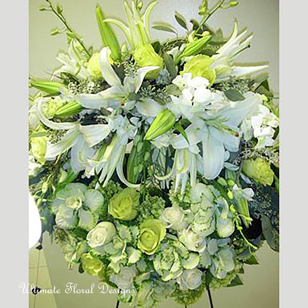 Large white and green floral arrangement with lilies and roses