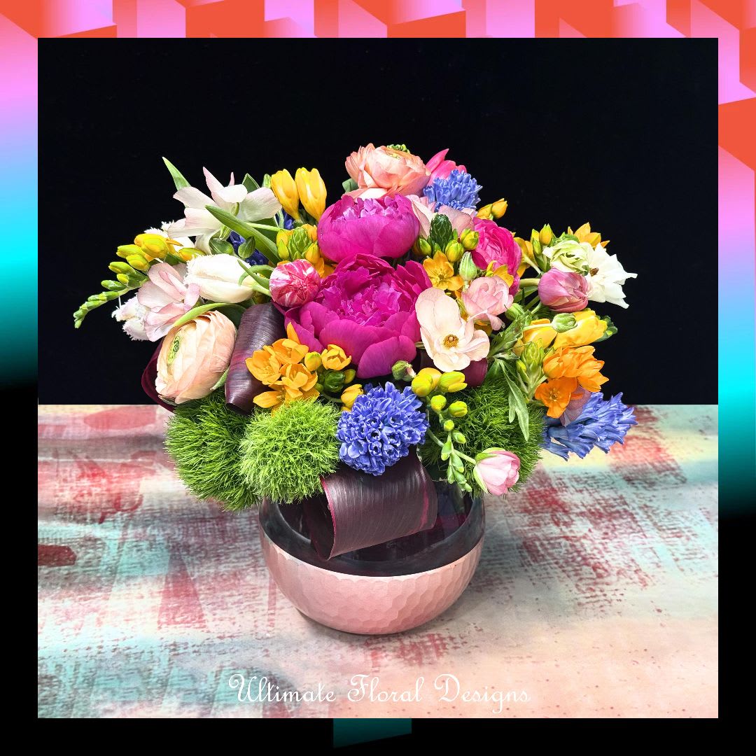 Colorful mixed flower arrangement in a pink bowl vase