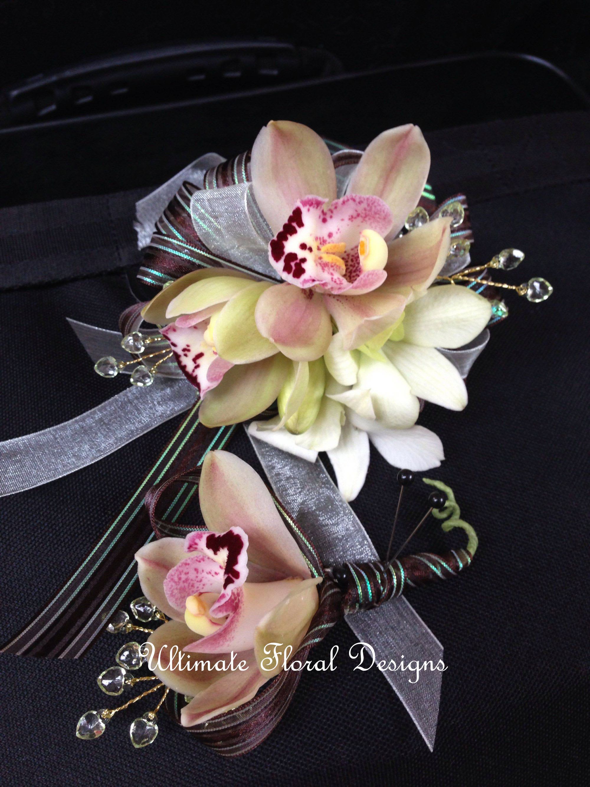 Two orchid corsages with silver and burgundy ribbon accents