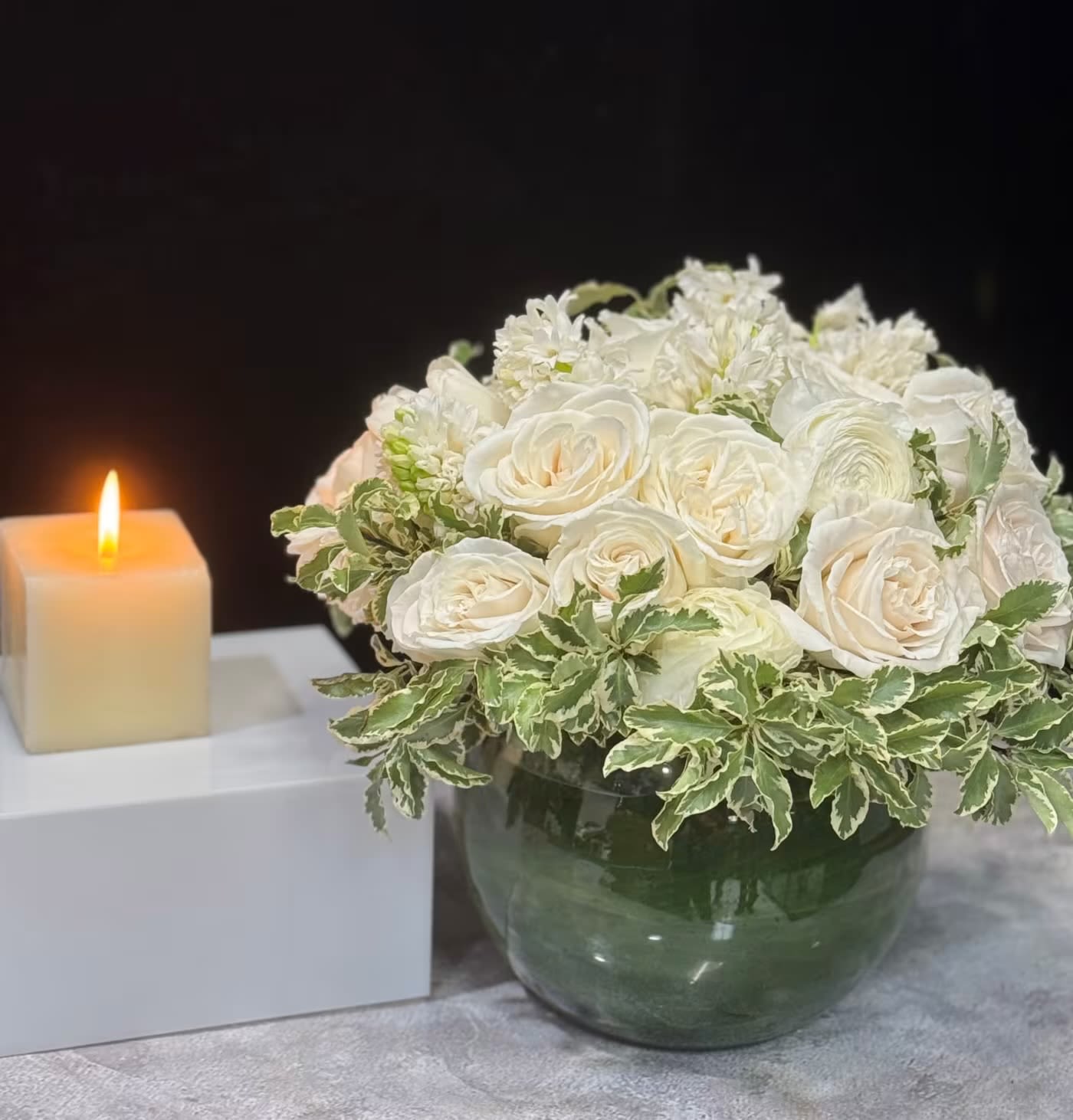 Ivory Garden Elegance - Brighten any space with the effortless charm of Ivory Garden Elegance. Featuring lush white garden roses, delicate hyacinths, ranunculus, and fresh variegated greenery, this arrangement is designed to make a statement. Whether you’re celebrating life’s special moments, elevating your home décor, or surprising someone with a thoughtful gift, this floral design brings elegance and warmth to every setting.  Perfect for birthdays, anniversaries, dinner parties, corporate events, or simply to add a touch of sophistication to your space. Whatever the occasion, Ivory Garden Elegance is a stunning choice that speaks to all.  Available for custom orders. Let us bring beauty to your next celebration!