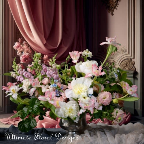 Large pastel floral arrangement in a silver vase with pink and white blooms