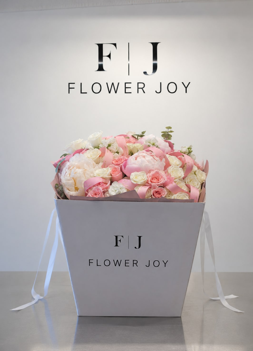 Peony Blush Box - A luxurious arrangement of soft pink and ivory roses, lush peonies, delicate seasonal blooms, and fresh greenery, beautifully presented in a signature Flower Joy box. Romantic, elegant, and perfect for birthdays, anniversaries, engagements, or meaningful celebrations.
