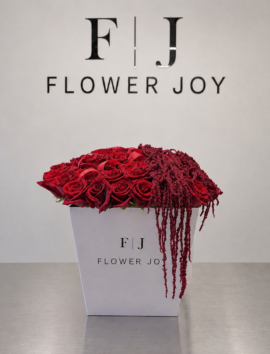 Crimson Cascade Rose Box - A dramatic arrangement of rich red roses accented with cascading burgundy amaranthus, beautifully presented in a signature Flower Joy box. Bold, romantic, and luxurious, perfect for anniversaries, proposals, Valentine’s Day, or an unforgettable expression of love.