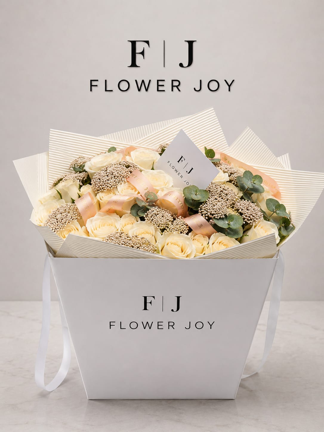 Elegant Cream Rose Gift Box - A luxury Flower Joy floral box filled with elegant cream-white roses, soft peach ribbons, eucalyptus leaves, and textured filler flowers.