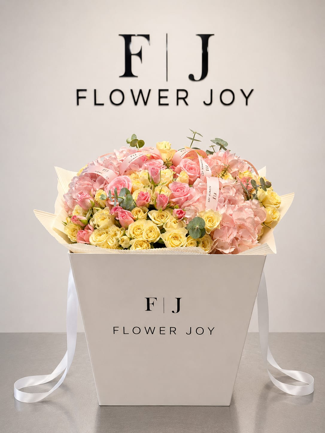 Pastel Bloom Box - A charming arrangement of blush pink and soft yellow roses, delicate hydrangeas, and fresh eucalyptus, beautifully presented in a signature Flower Joy box. Sweet, elegant, and full of warmth, perfect for birthdays, congratulations, baby showers, or any joyful celebration.