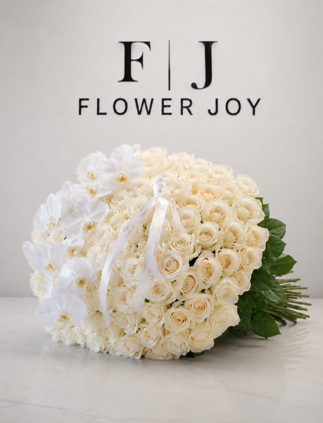 Pure Elegance Bouquet (75 items) - A graceful arrangement of ivory roses and delicate white orchids, finished with elegant ribbon details. Timeless and refined, it is perfect for weddings, anniversaries, congratulations, or any meaningful celebration. 