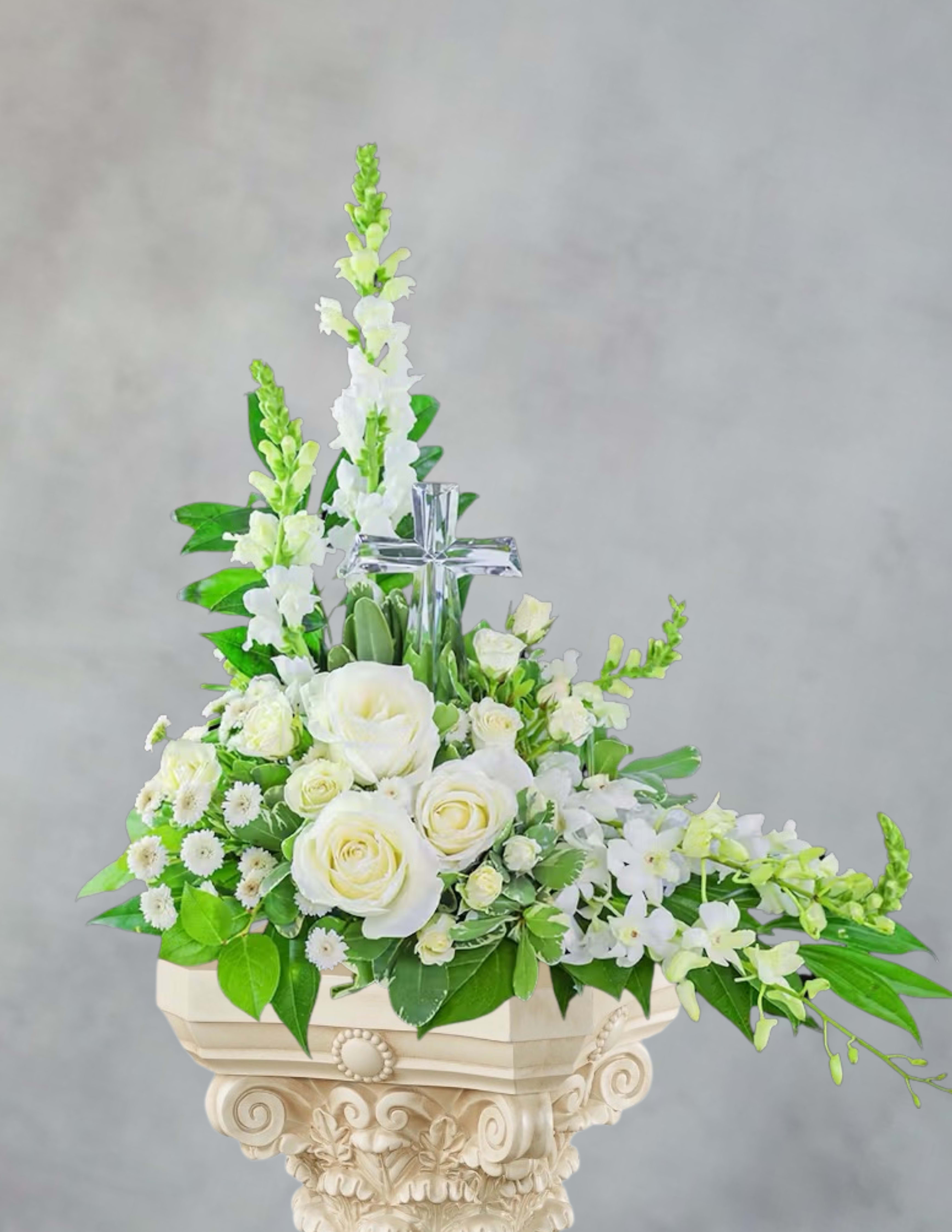 White rose and orchid arrangement with a clear cross centerpiece