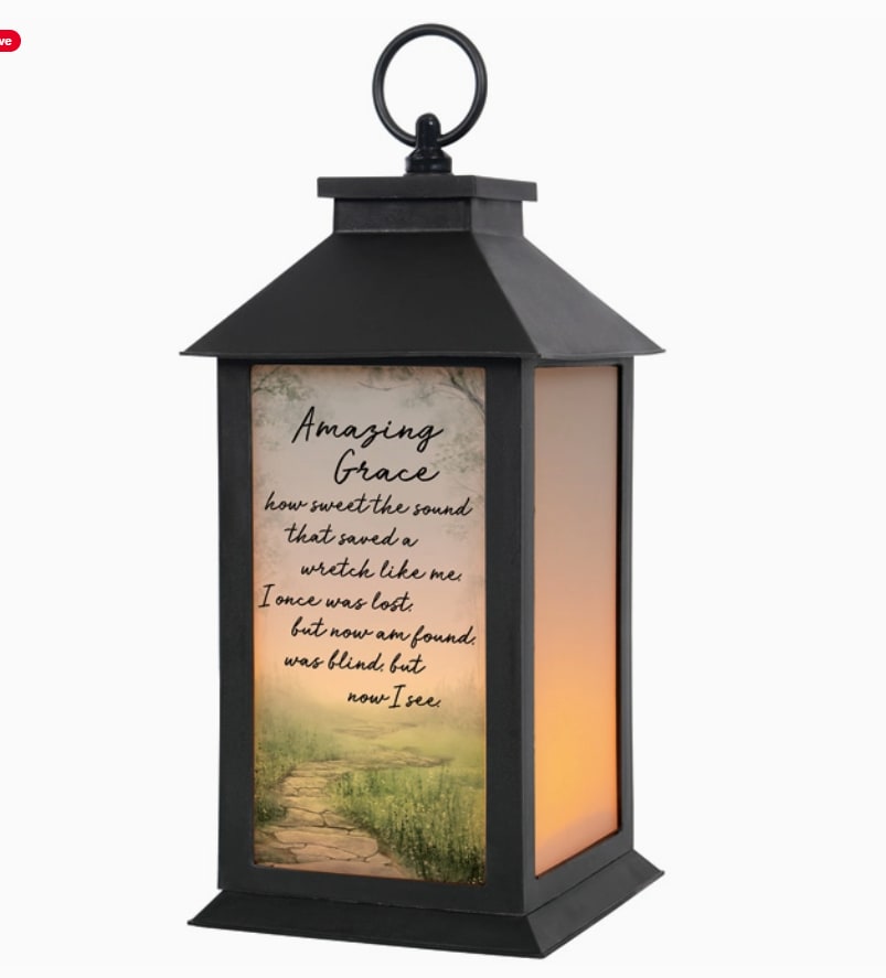 Black lantern with a printed "Amazing Grace" panel and warm light inside