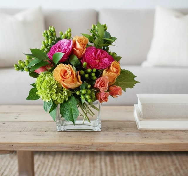 Vivid Daydream - A vibrant gathering of peach roses, hot pink garden roses and immature green hydrangea with berried accents.  Artfully placed in a 5" cube vase..   Overall size is Approx 10" x 10"