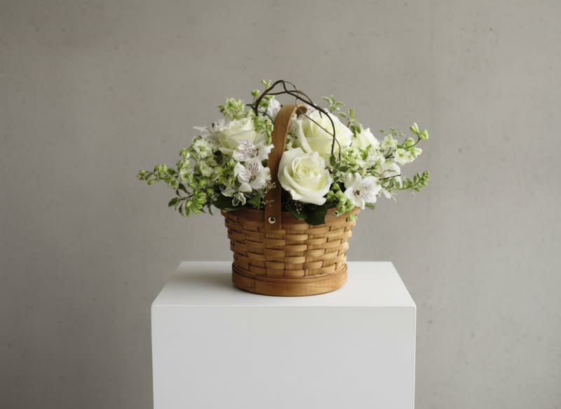 The Peaceful Garden Basket - The Peaceful Garden Basket offers warmth and comfort through its display of snow-white blooms. Roses, Snaps and Peruvian lilies are accented with curly willow tips and an assortment of lush greens. The bouquet is artfully arranged in a natural round woodchip basket, creating the perfect way to convey your wishes.  Small 75 Medium 125 Large 200