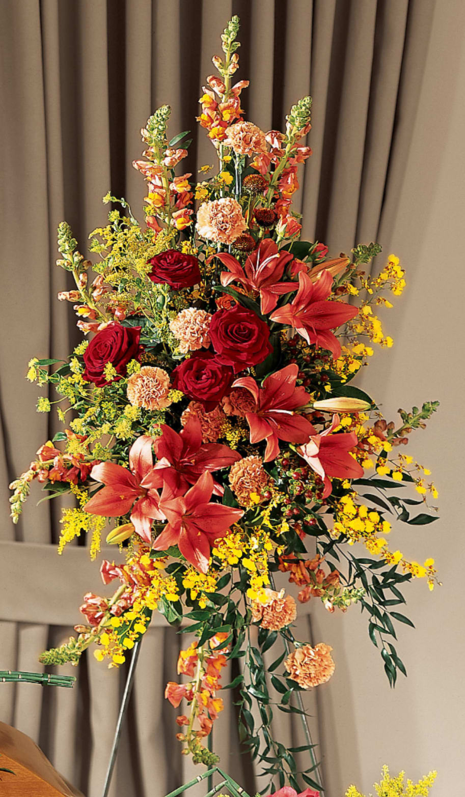 Tall floral spray with red lilies, roses, and yellow filler flowers