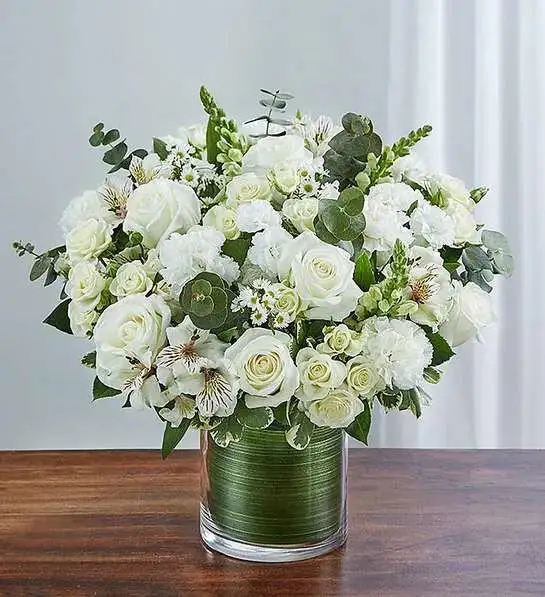 Cherished Memories All White - Memories are timeless treasures of the heart, meant to be cherished. Our striking, all-white sympathy arrangement of roses, snapdragons, alstroemeria and more, elegantly designed by hand in a graceful cylinder vase, is a touching tribute to a life well lived and the memories that will be held dear forever.