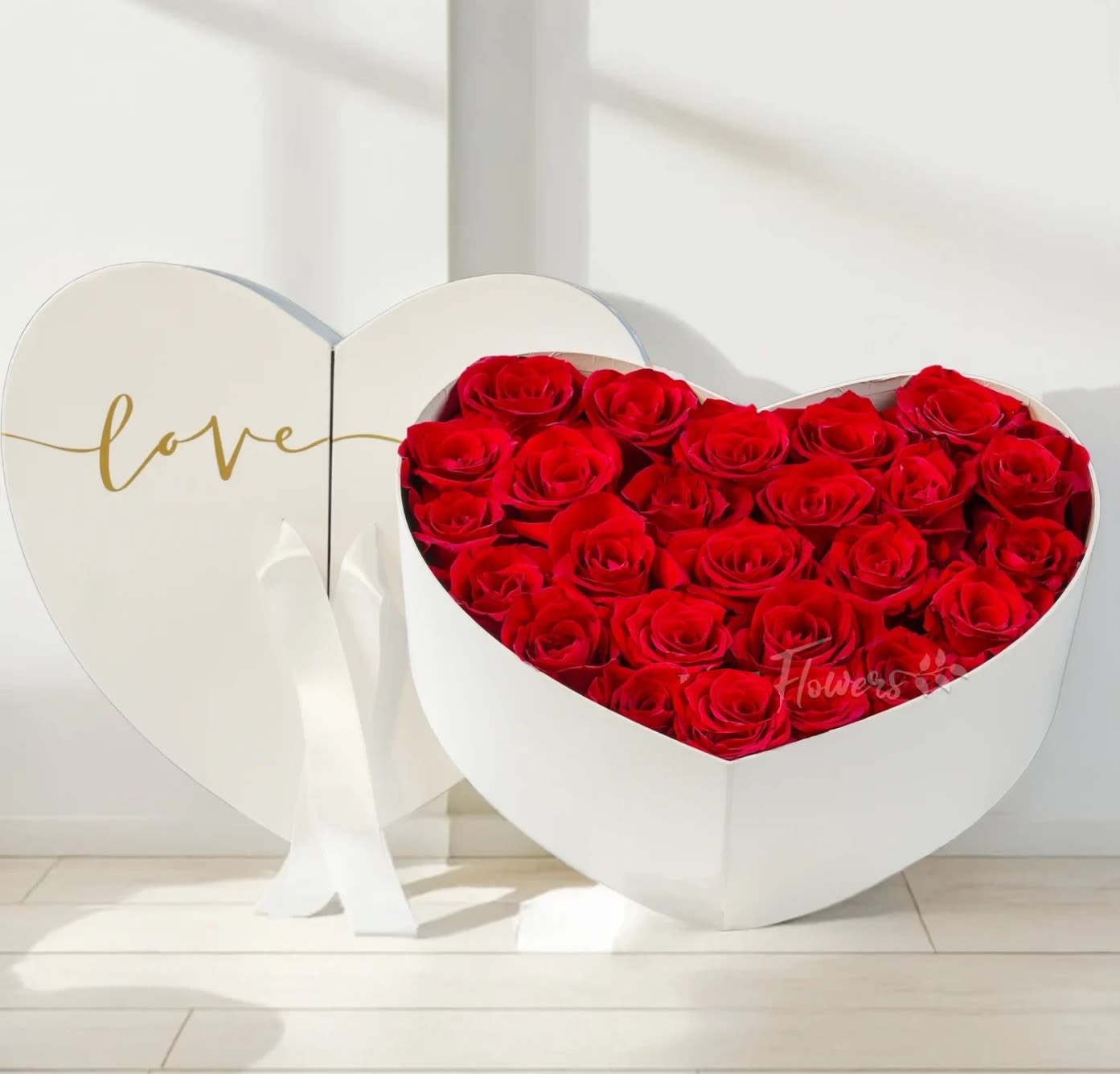 Heart-shaped box of red roses with a matching heart lid reading love