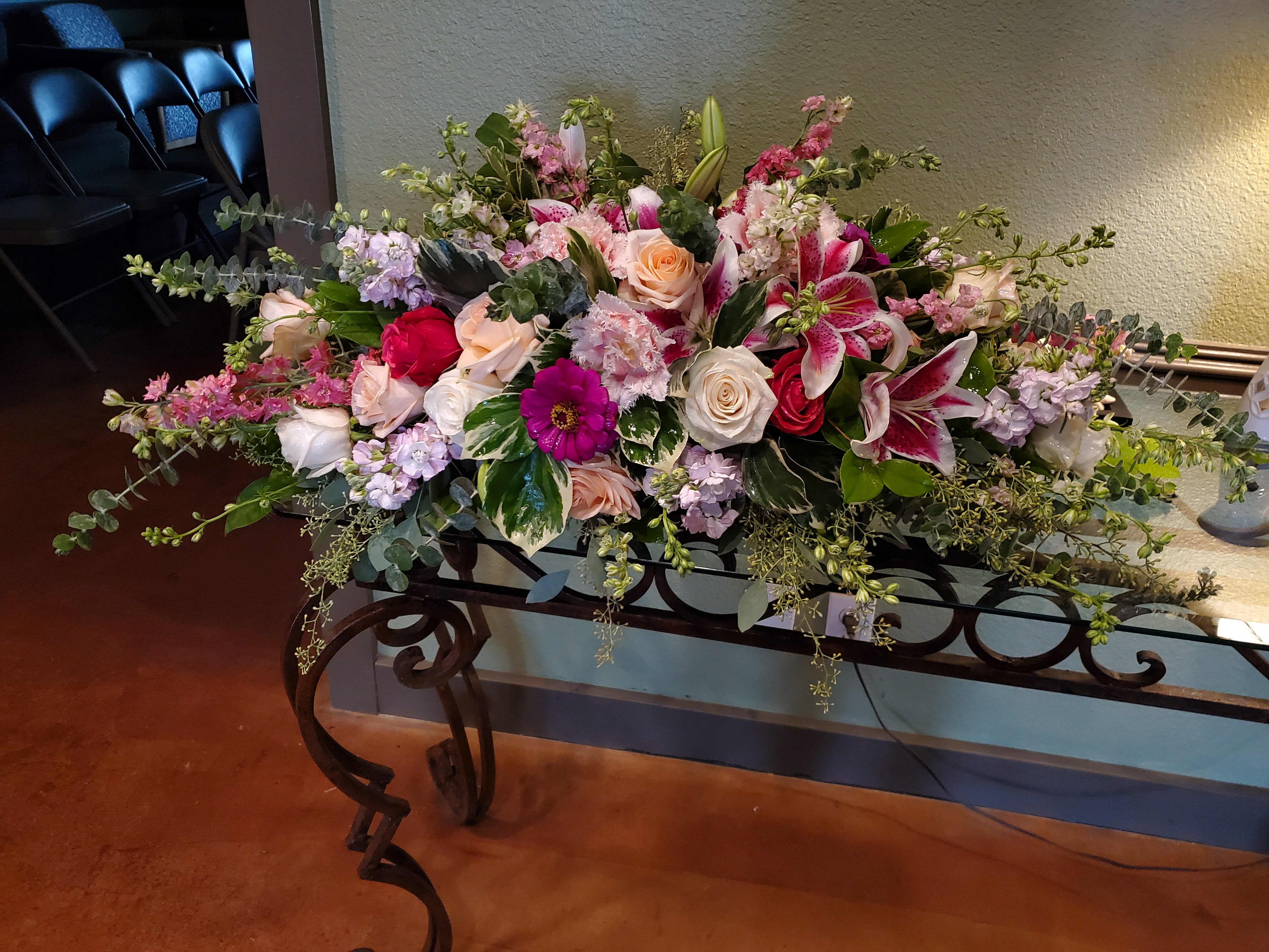 Large mixed floral arrangement with pink lilies and roses on a table