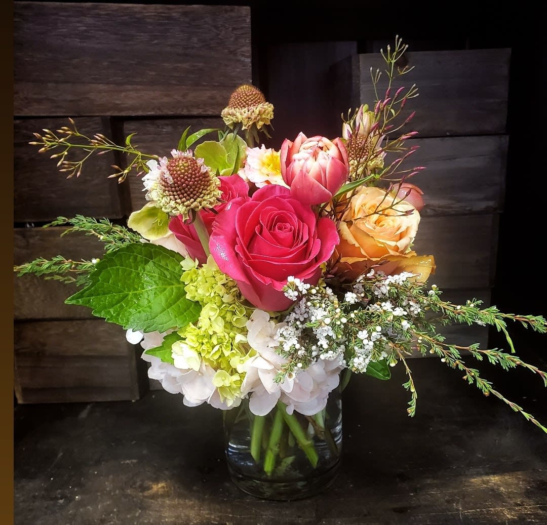 Mixed bouquet of pink and peach roses in a glass vase