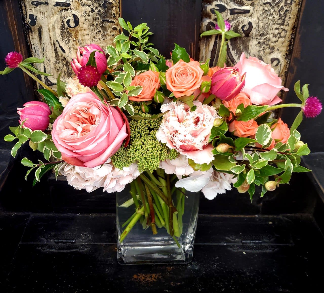 Pink and peach roses arranged in a clear glass vase