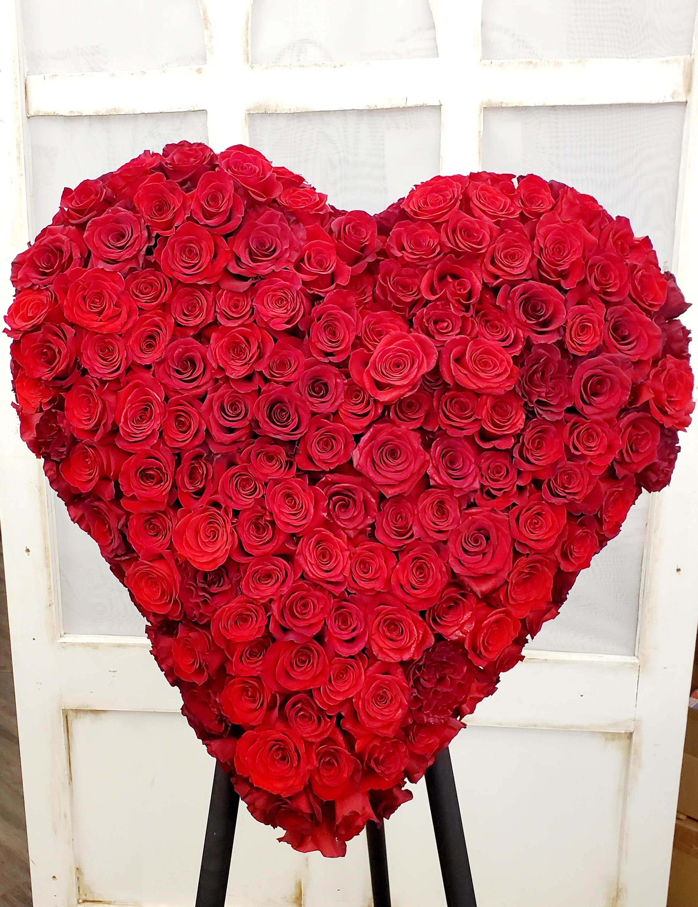 Heart-shaped arrangement of red roses on a stand