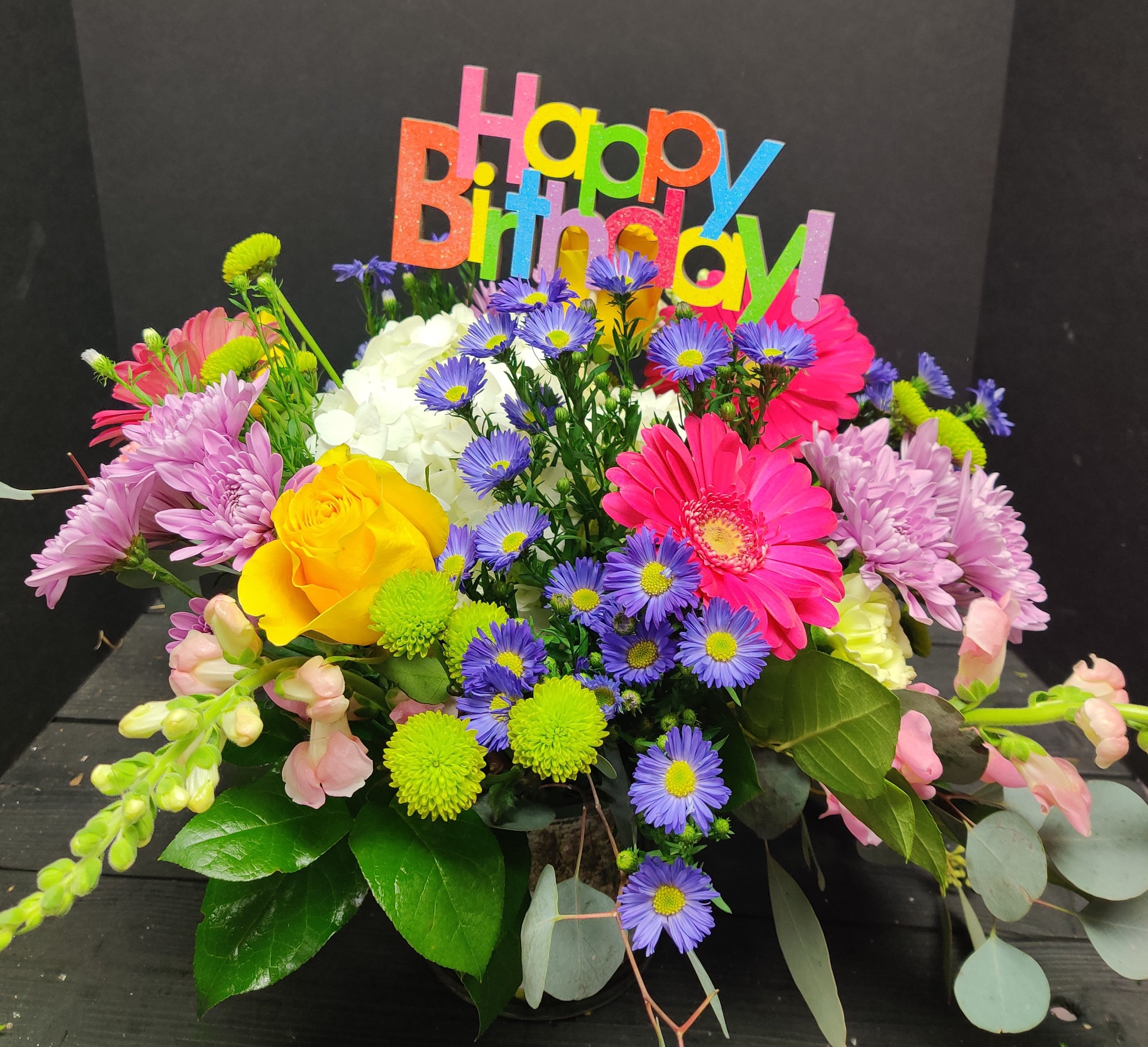 Colorful birthday bouquet with mixed flowers and a "Happy Birthday" sign