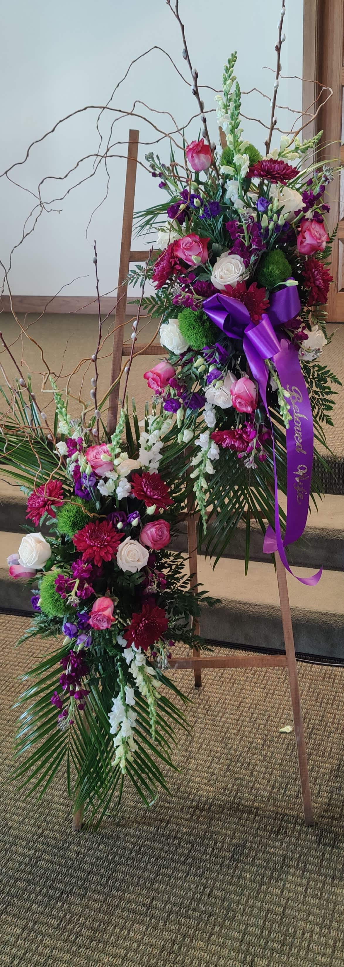 Two floral standing sprays with pink, white, and purple flowers on easels