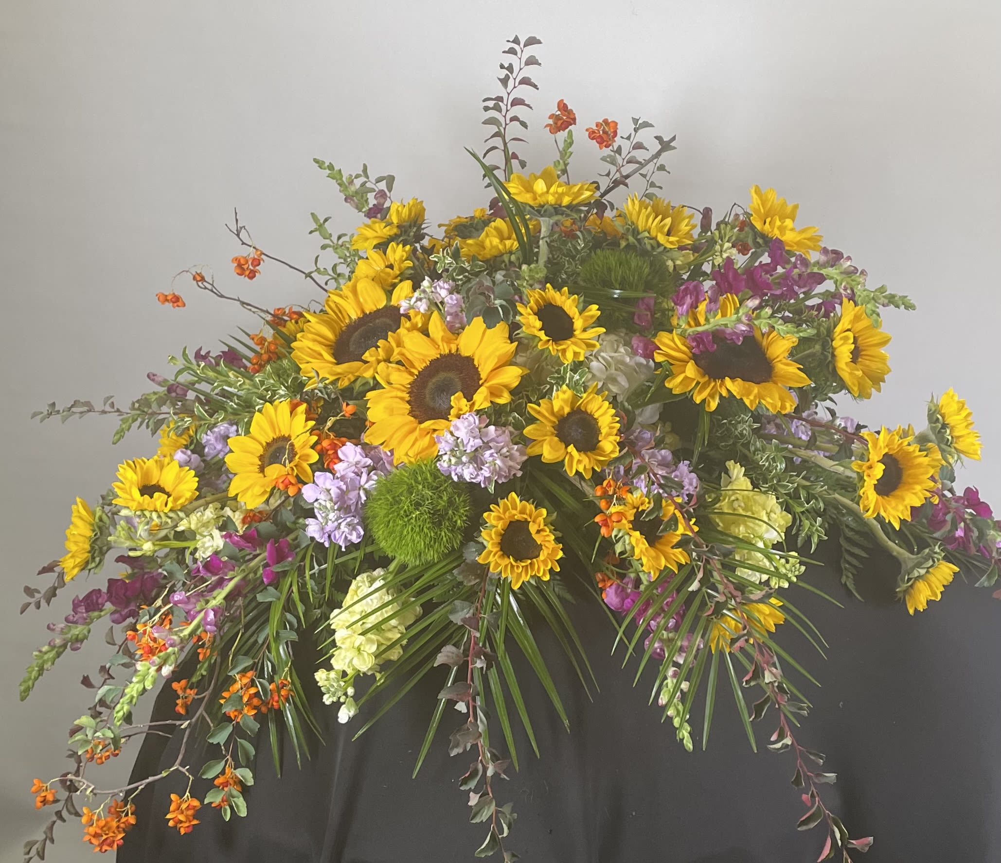 Large floral spray with sunflowers and purple blooms