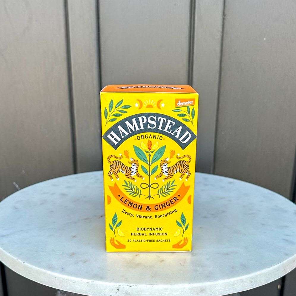 Box of Hampstead Organic Lemon &amp; Ginger herbal tea on a round marble table