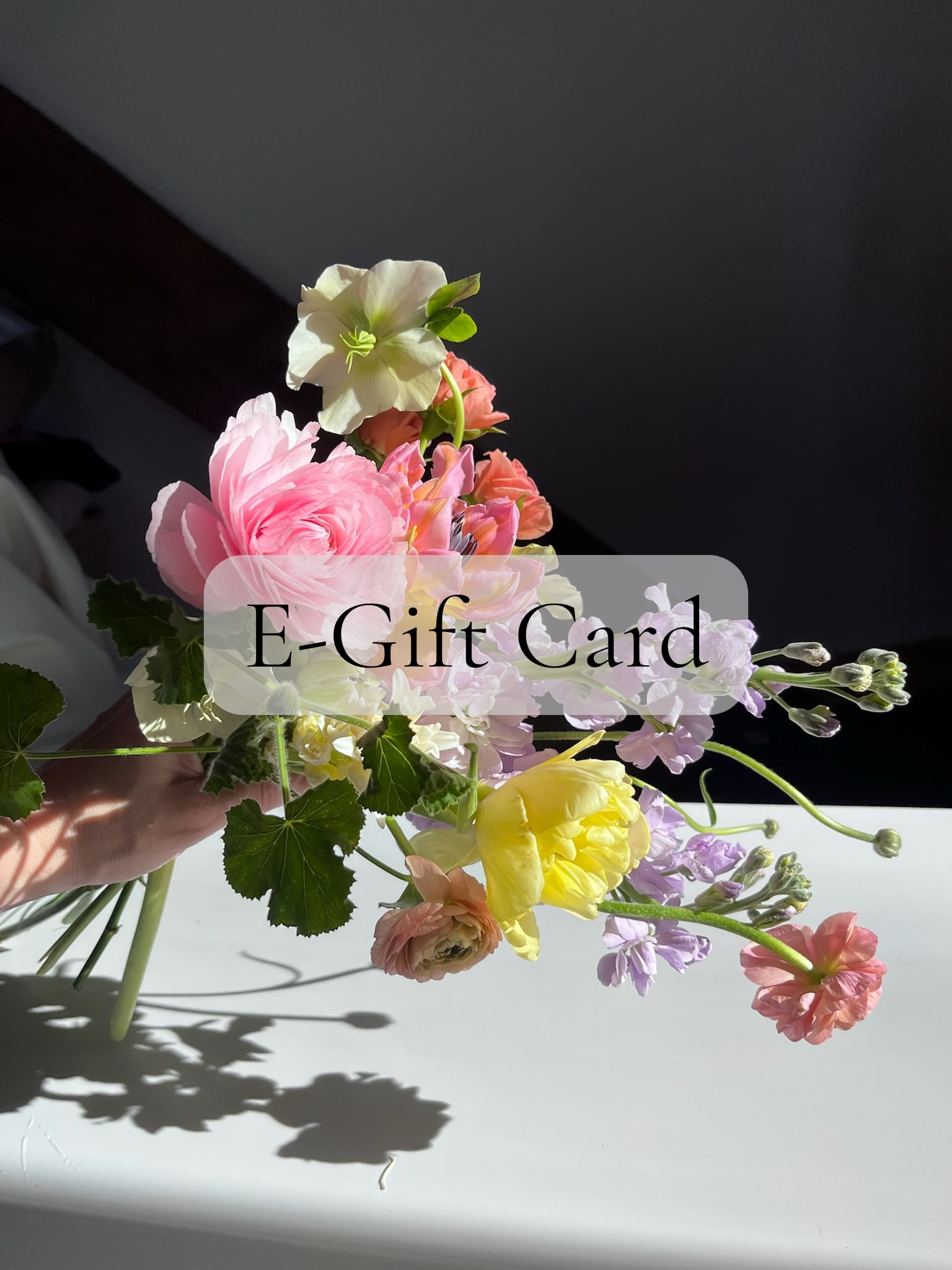 Pastel bouquet of mixed flowers with text reading “E-Gift Card” over the arrangement