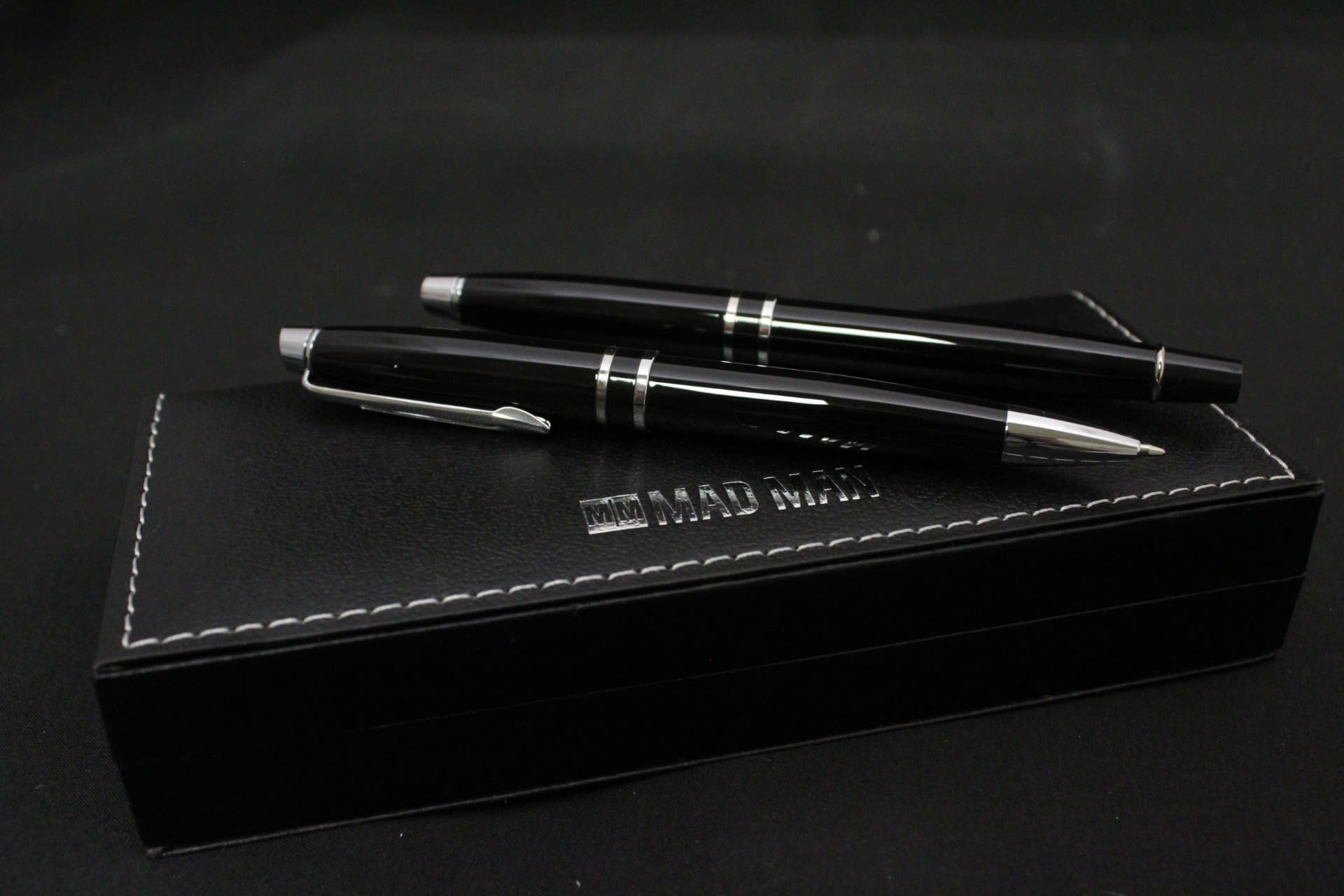 Silver &amp; Black Pen Set - A sleek, monochrome gift set made for a professional moment - perfect as a thoughtful birthday or congratulations gift for the colleague, boss, or grad heading into a new role. The look of a refined desk accessory with the immediacy of gift-giving: two glossy black pens with silver accents presented in a stitched black presentation box giving the set a tailored, masculine feel ideal for promotions, retirements, or corporate thank-you gifts. 