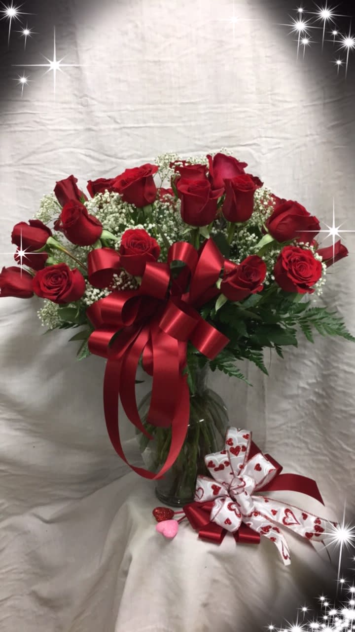 Bouquet of red roses with a red ribbon in a glass vase