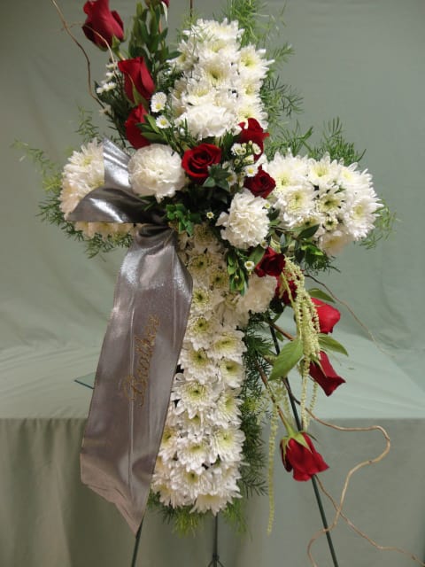 Standing floral spray with white chrysanthemums and red roses, accented by a silver ribbon