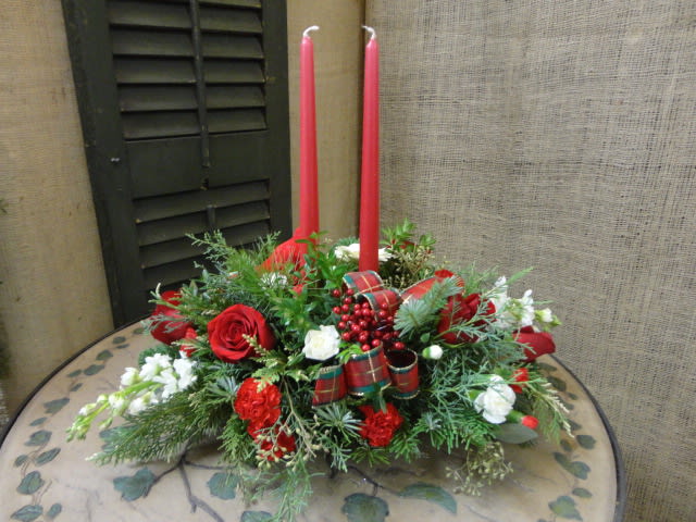 Red and white floral centerpiece with two tall red candles