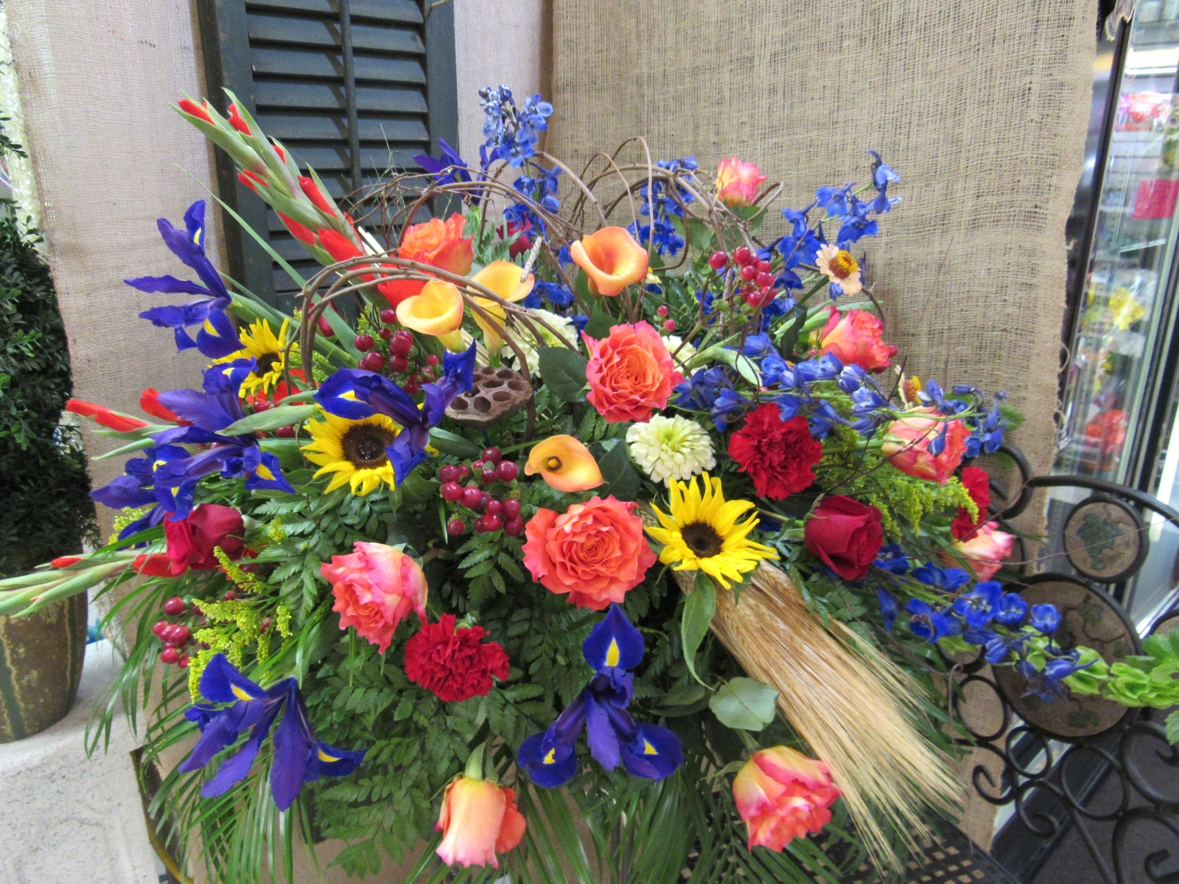 Colorful mixed flower arrangement with roses, irises, sunflowers, and calla lilies