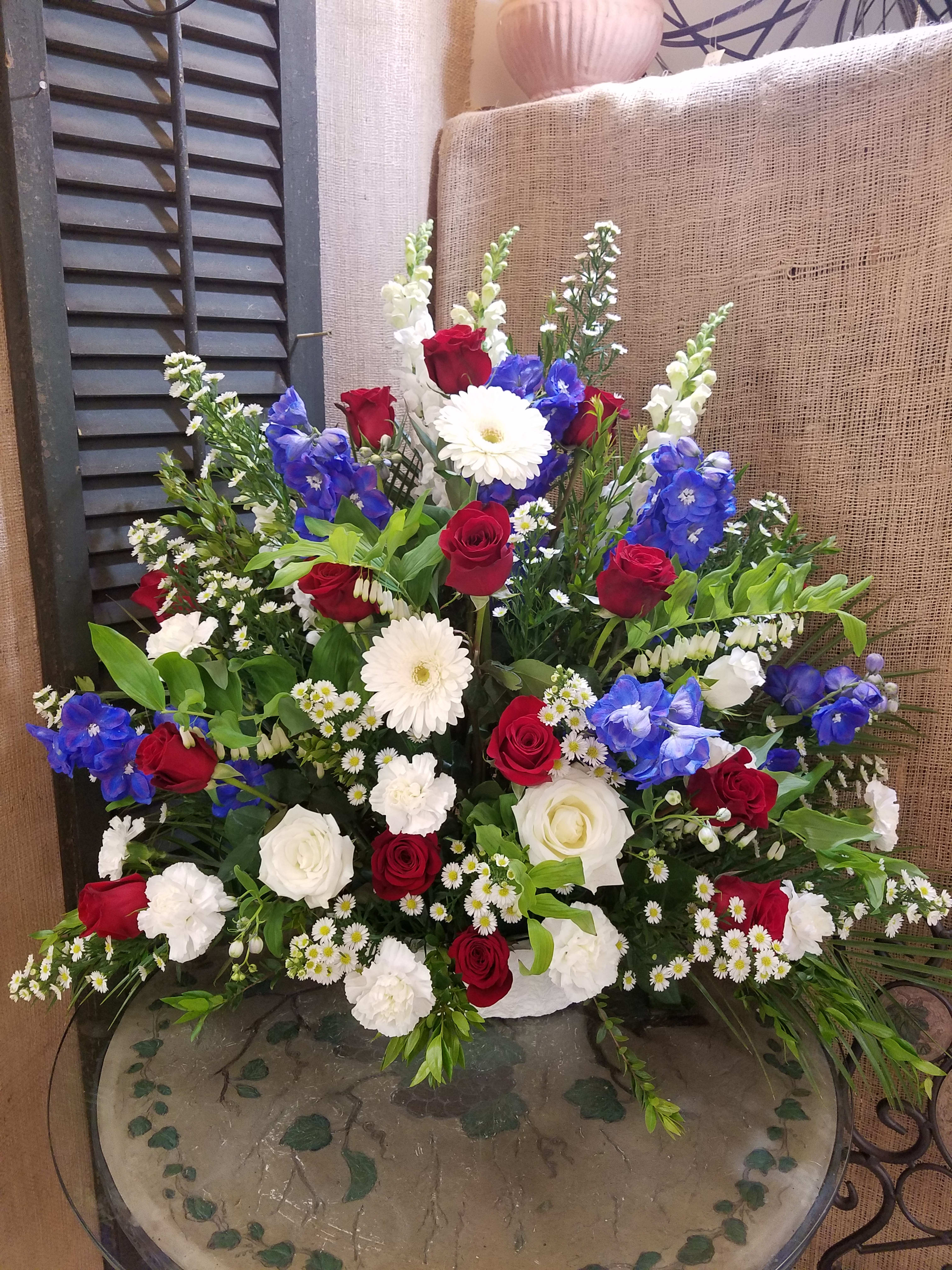 Large mixed bouquet with red and white roses, blue flowers, and white daisies