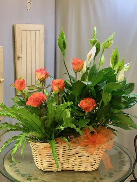 Orange roses and white calla lilies in a wicker basket