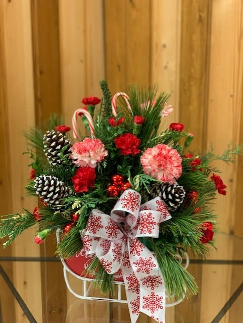 Christmas arrangement with pinecones, candy canes, and a snowflake ribbon